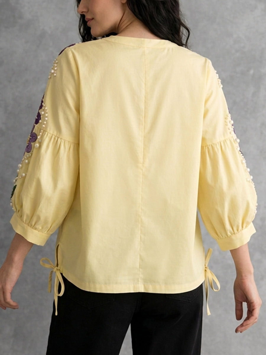 Gelbe Bluse mit Puffärmeln, seitlichen Schlitzen und femininer Stickerei