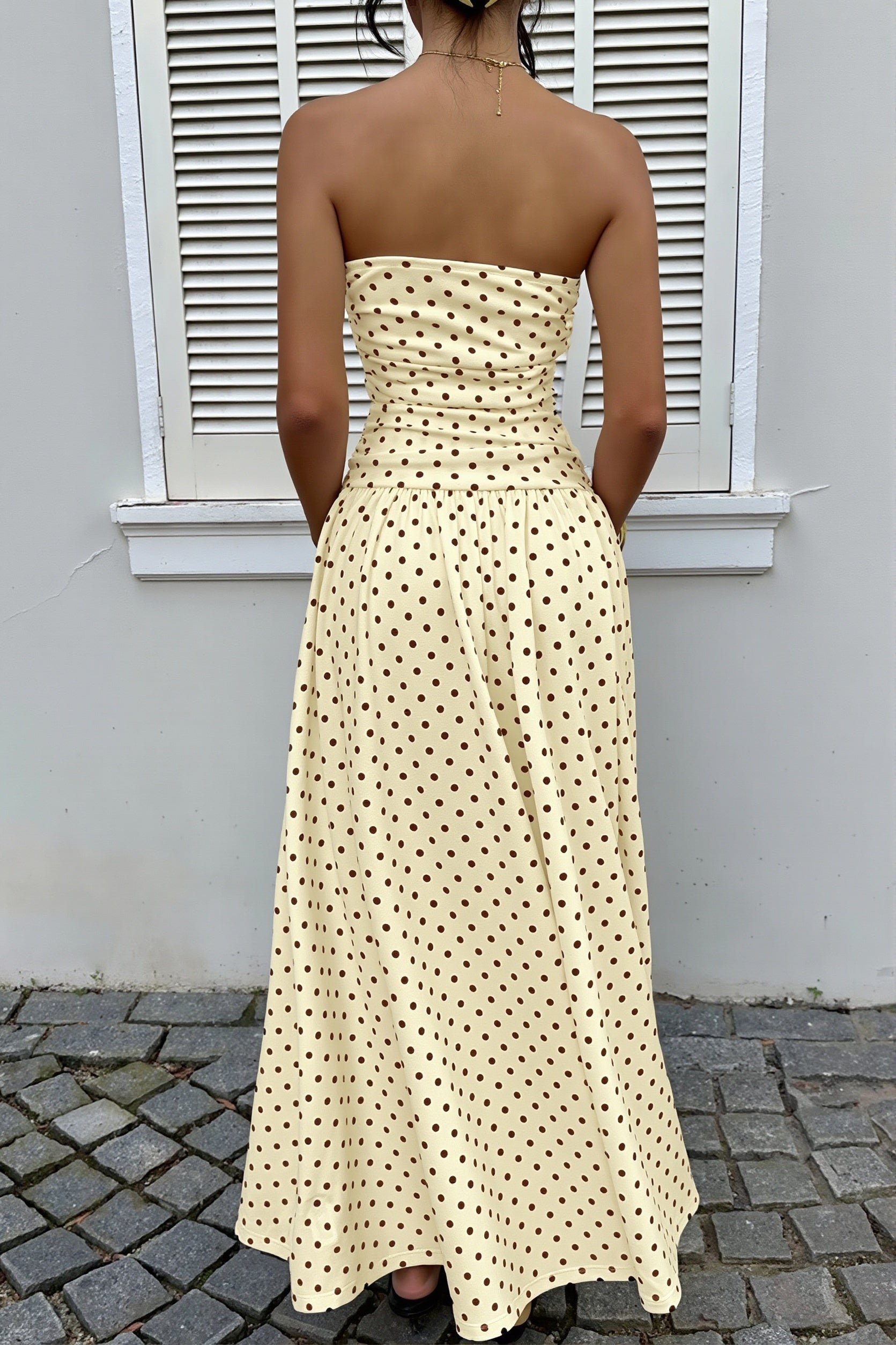 Trägerloses Punktkleid mit Volant und figurbetonter Silhouette im Detail