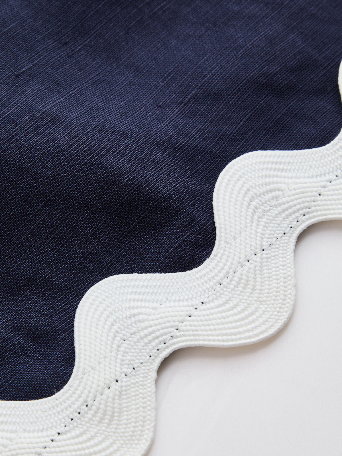 Detailaufnahme der Wellenkante am ärmellosen Minikleid aus Leinenmix