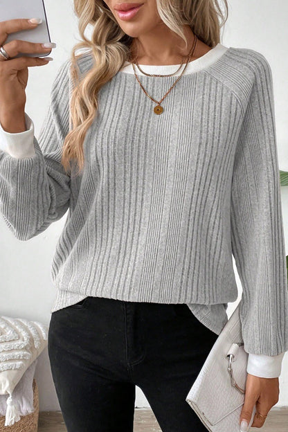 Nahaufnahme von Strickstruktur und Kontrastbesatz am Pullover