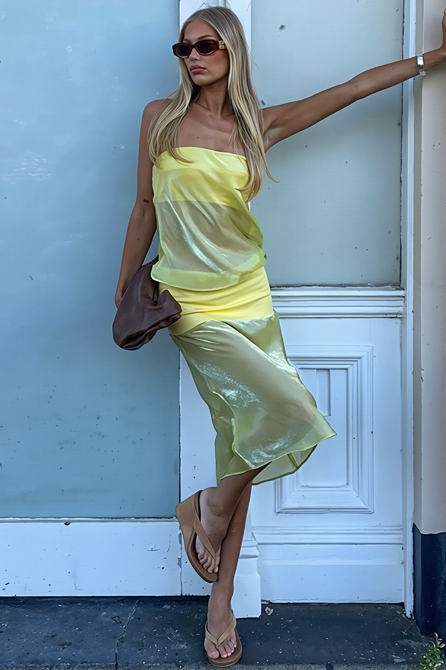 Damen trägt ein figurbetontes trägerloses Midikleid im eleganten Look