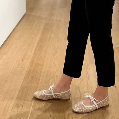 Nahaufnahme der Spitzenstruktur und Zierschleife an Damen-Ballerinas